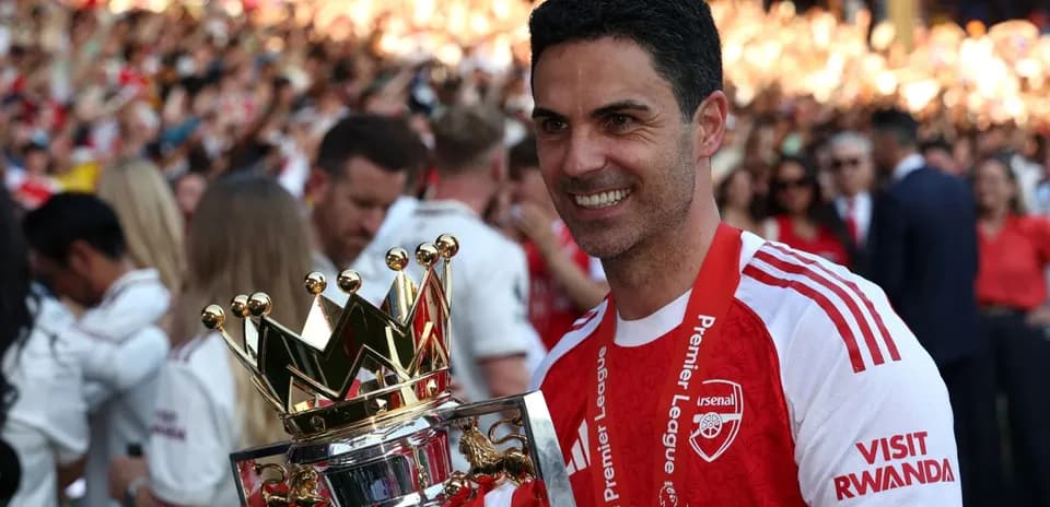 Manager holding Premier League trophy with fans celebrating