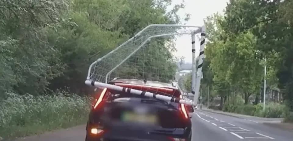 Car transporting a football goal on the roof