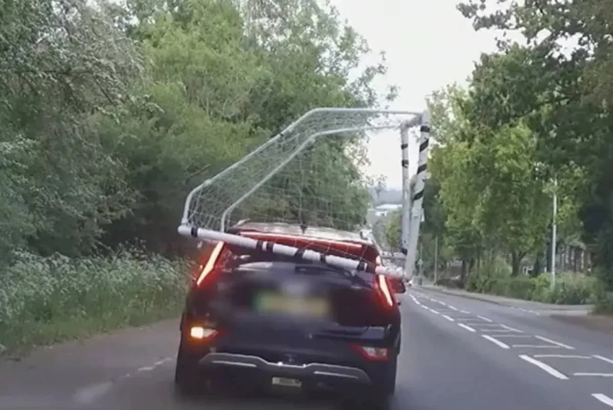 Car transporting a football goal on the roof