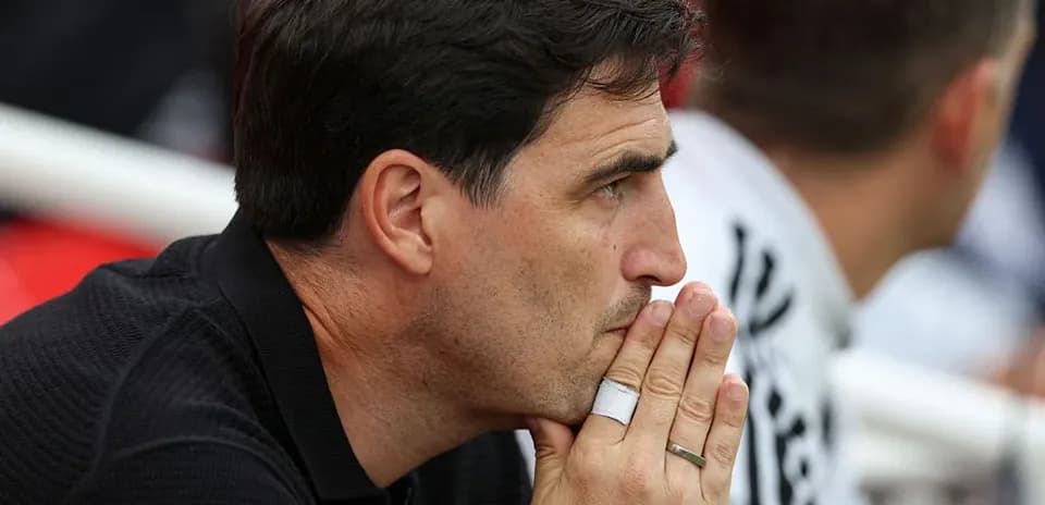 Coach observing the match with thoughtful expression