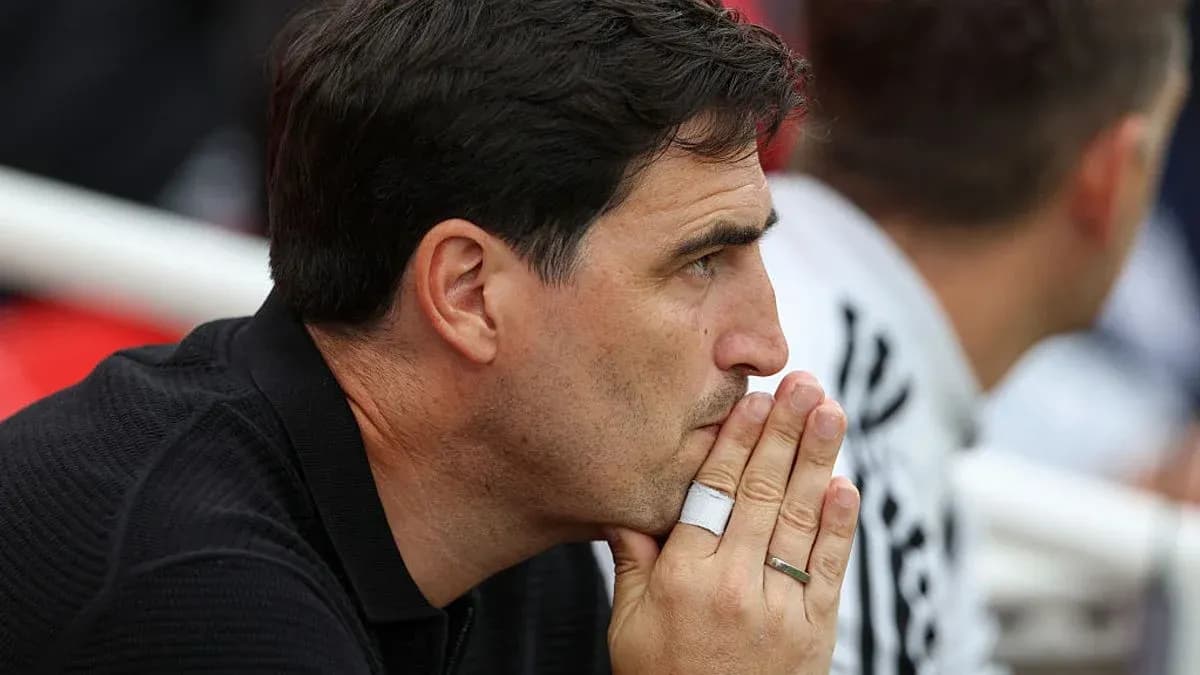 Coach observing the match with thoughtful expression