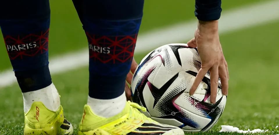 Player placing ball for set piece on pitch