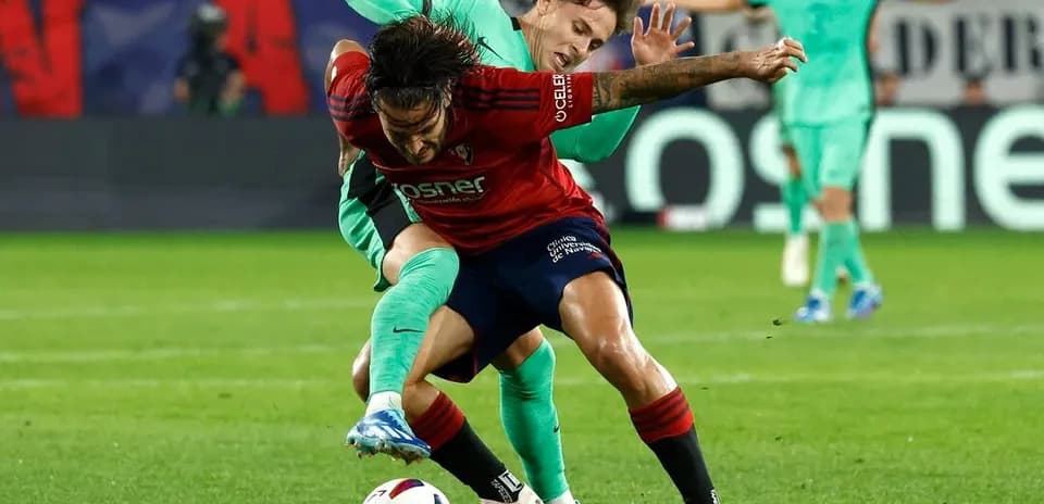Osasuna player challenged by Atletico Madrid player