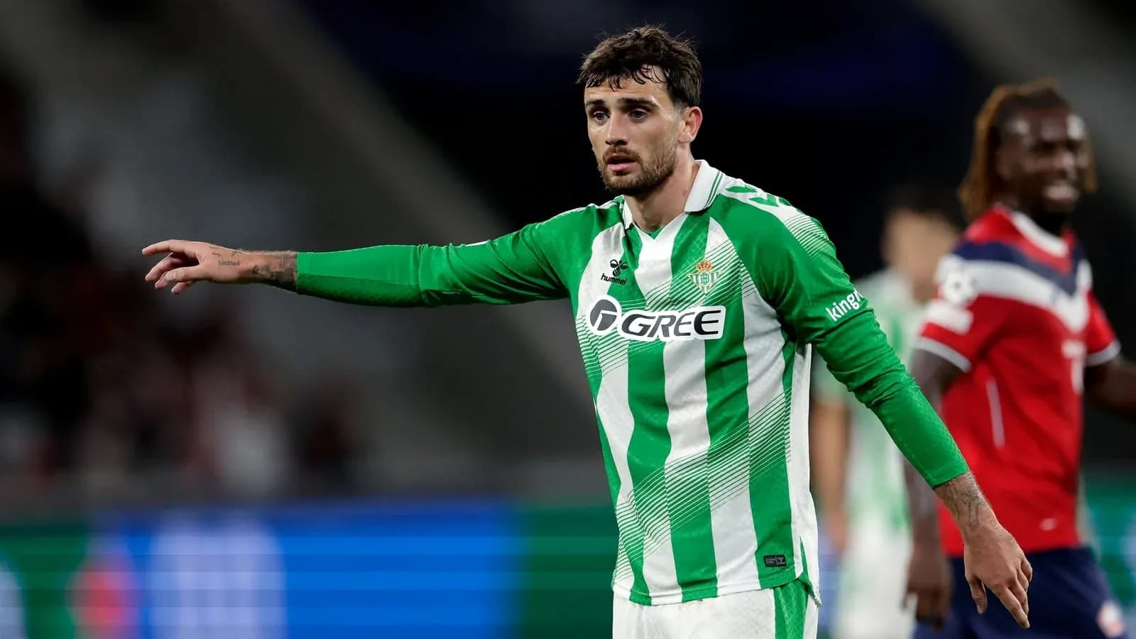 Player in green and white jersey directing teammates on field
