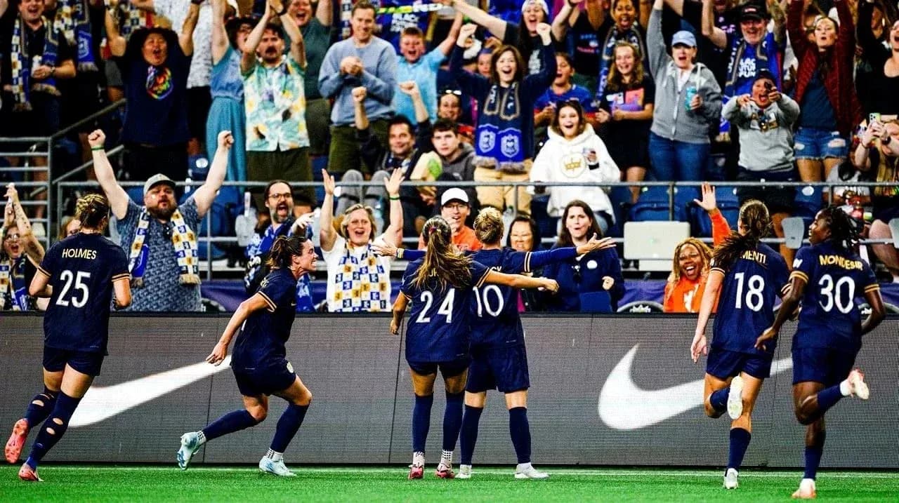 Players celebrating a goal with cheering fans
