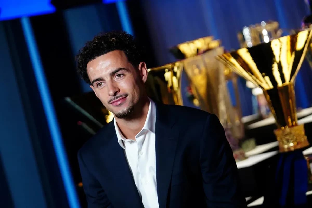 Player posing with trophies in the background