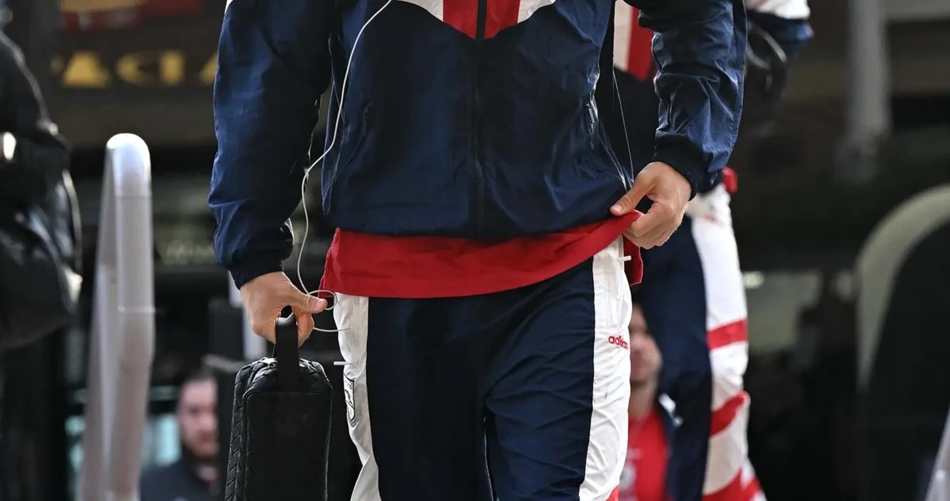 Player in team tracksuit arriving at venue