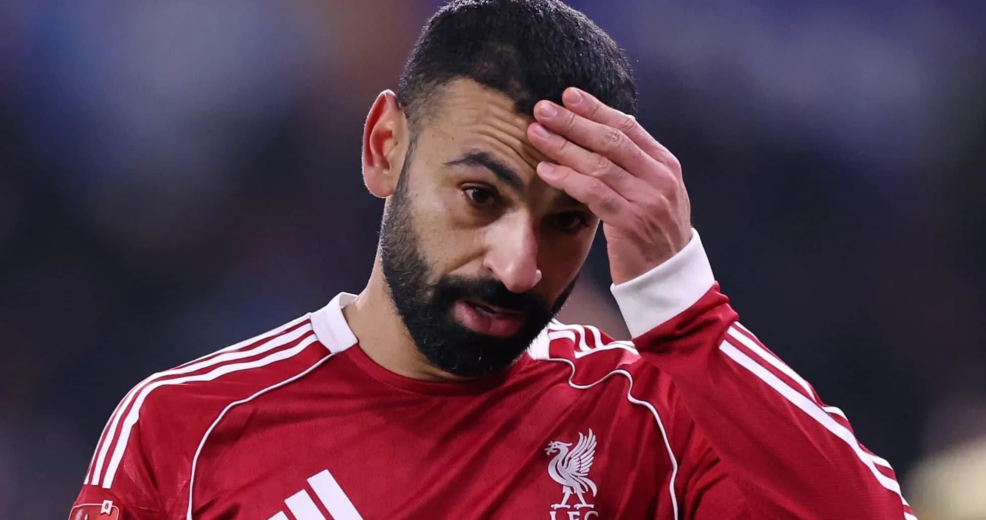 Player in red jersey touching his forehead