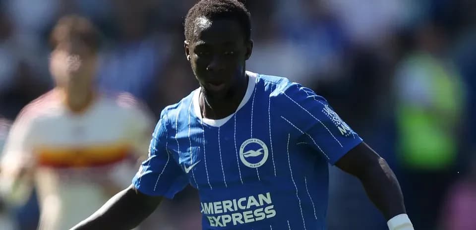 Player in blue kit dribbling the ball on pitch
