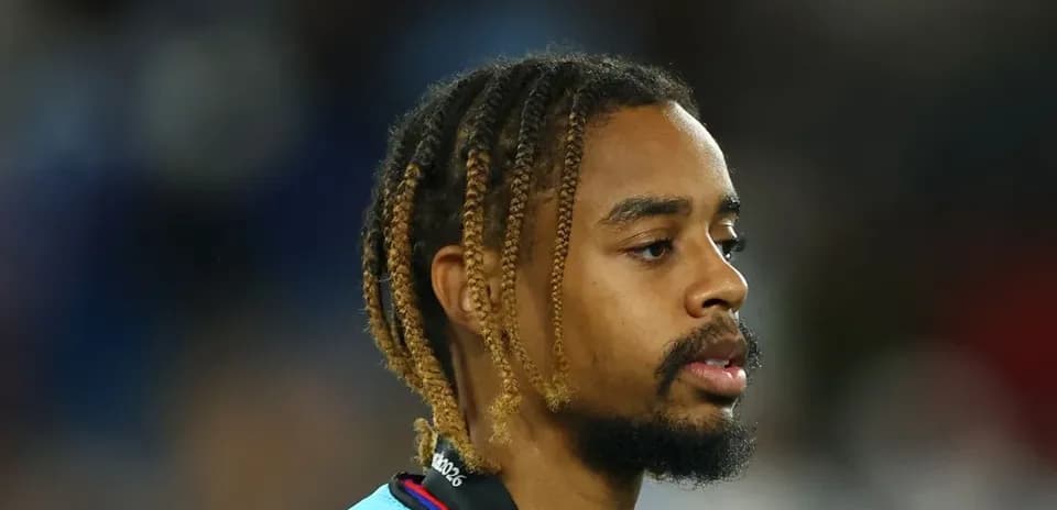 Player with braided hair on the sidelines