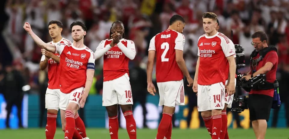 Arsenal players celebrating on the pitch after match