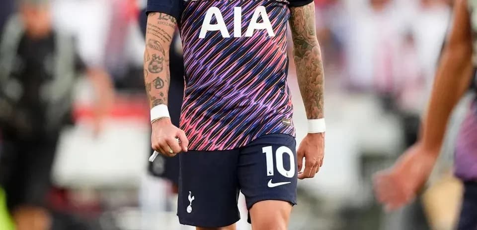 Player wearing Tottenham kit walking on the pitch
