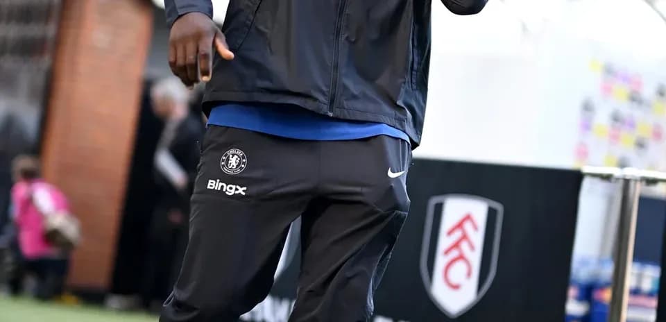 Player walking towards stadium entrance in team gear