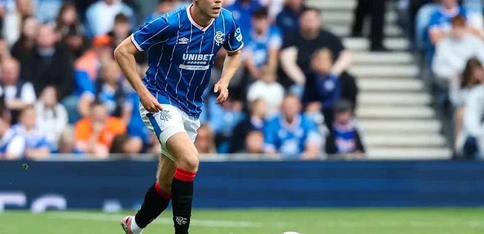 Player in blue kit running towards soccer ball