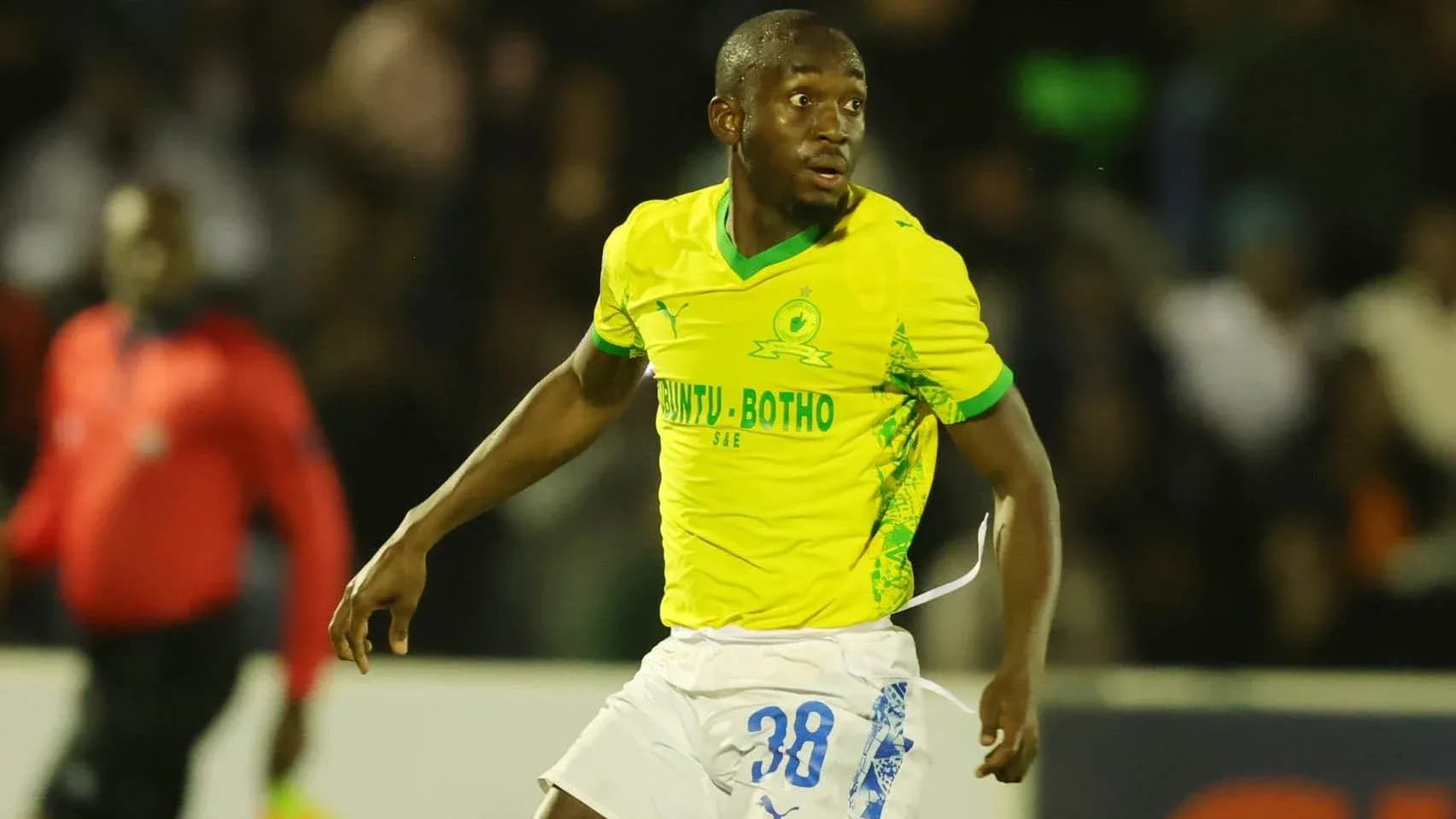 Player in yellow jersey running during a match