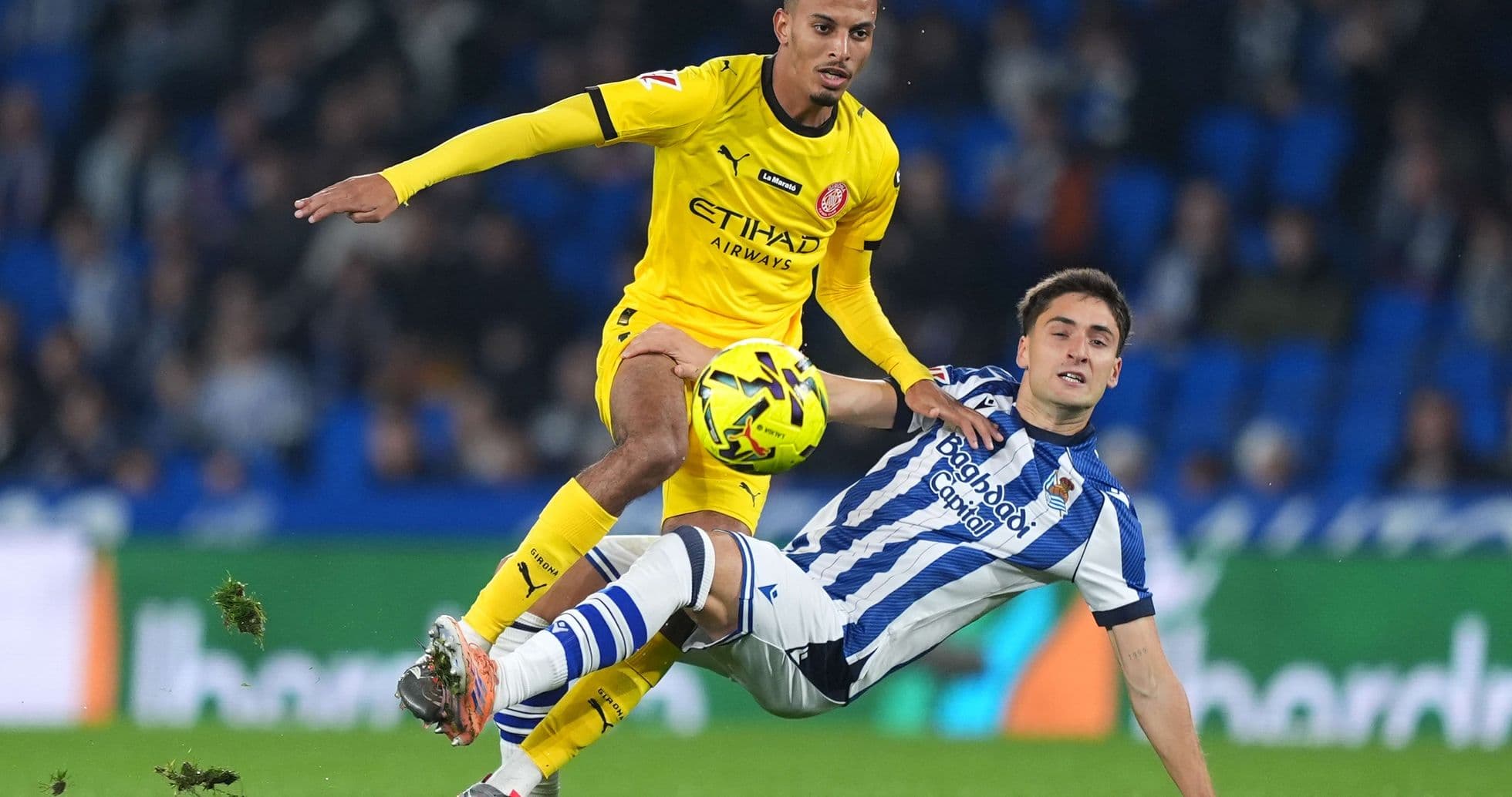 Girona player tackling Real Sociedad opponent