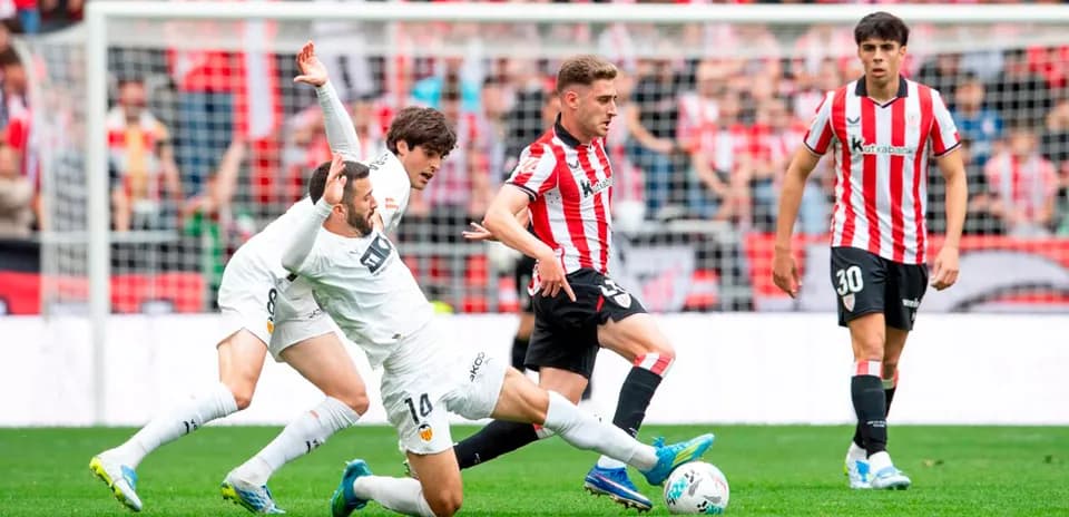Athletic Club players challenging Valencia during match