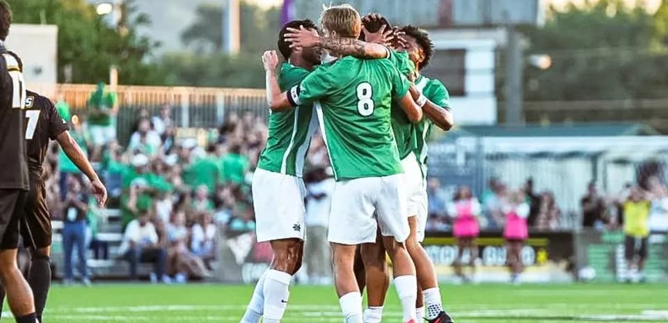 Players celebrating a goal on the field