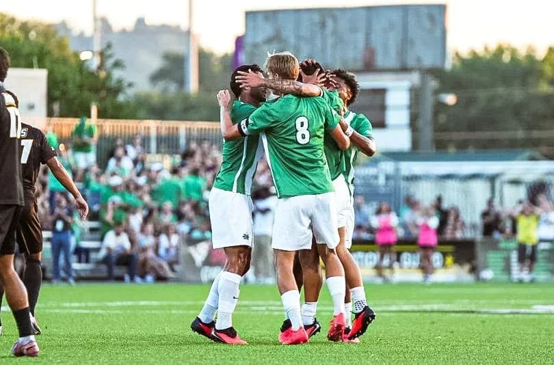 Players celebrating a goal on the field