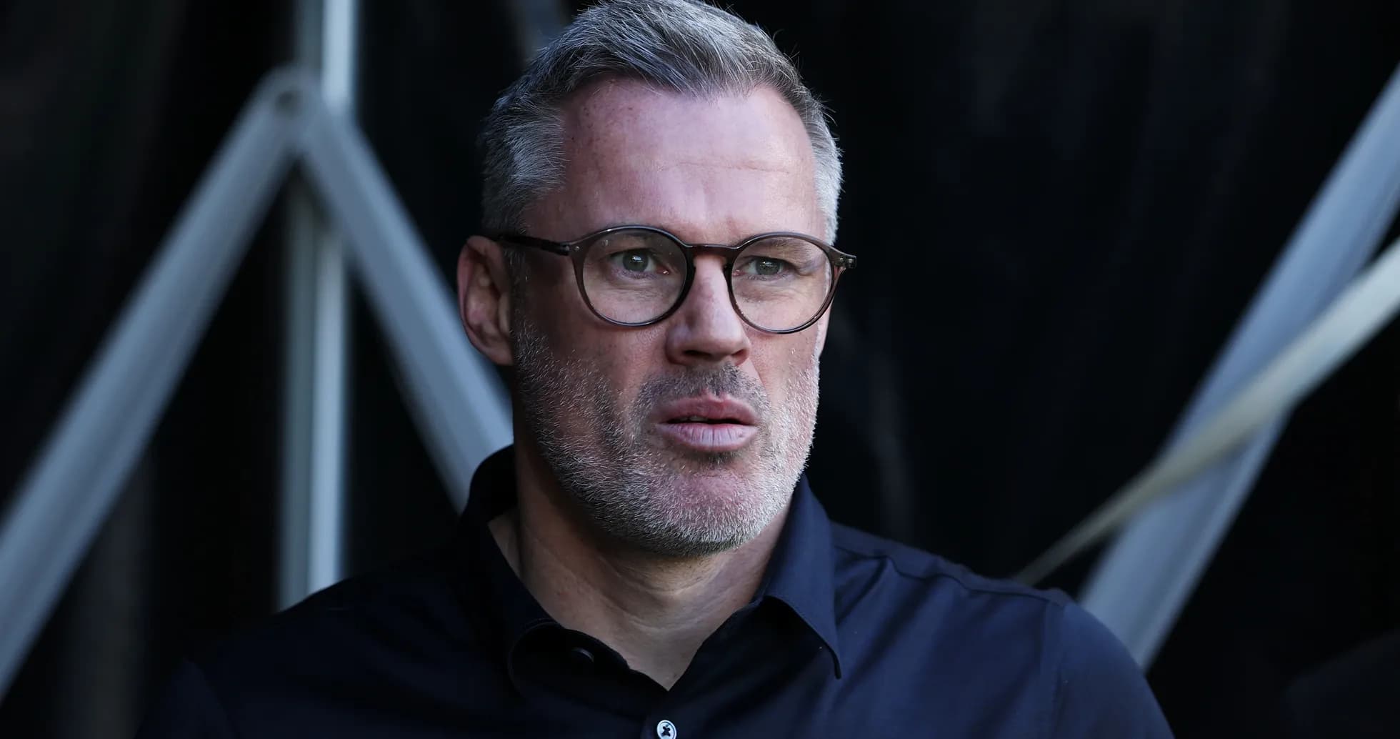 Man with glasses looking thoughtfully during event