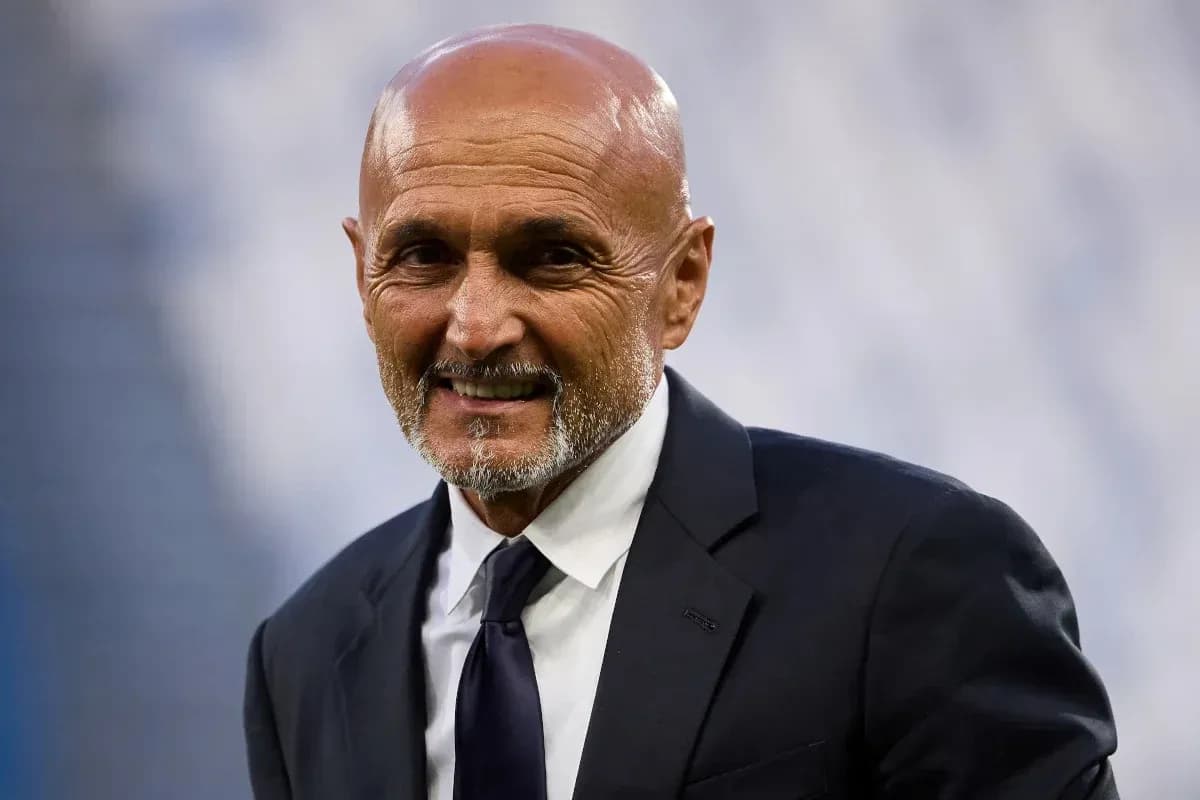 Coach smiling while wearing a suit on the field
