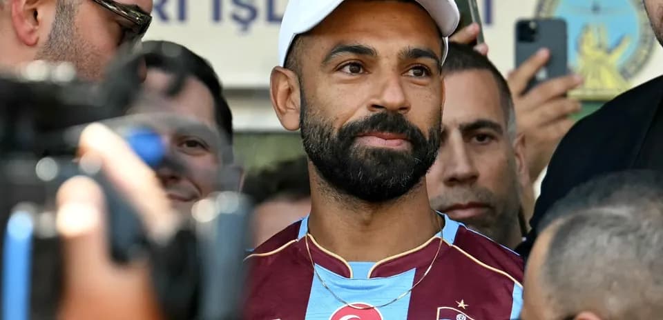 Player in Trabzonspor jersey surrounded by fans