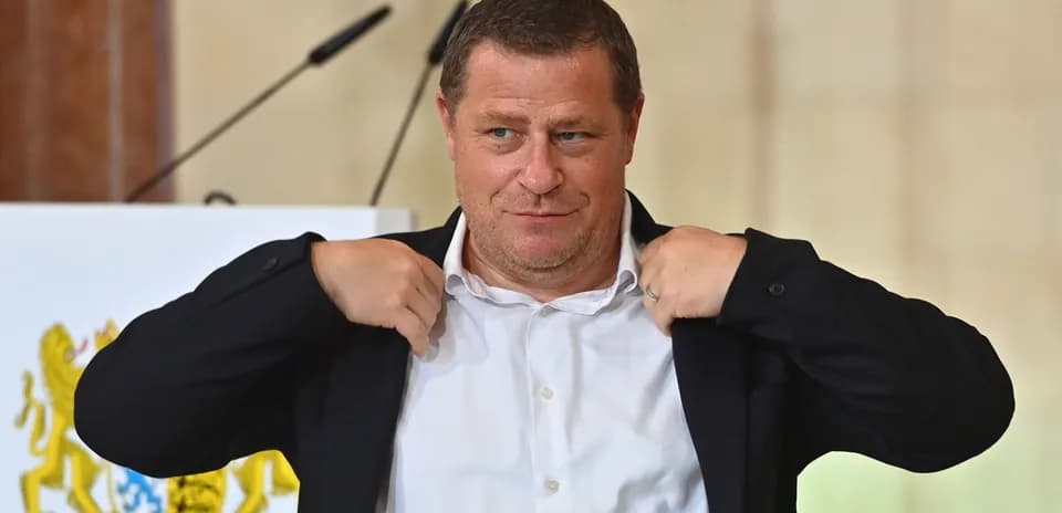 Man adjusting his jacket during press conference