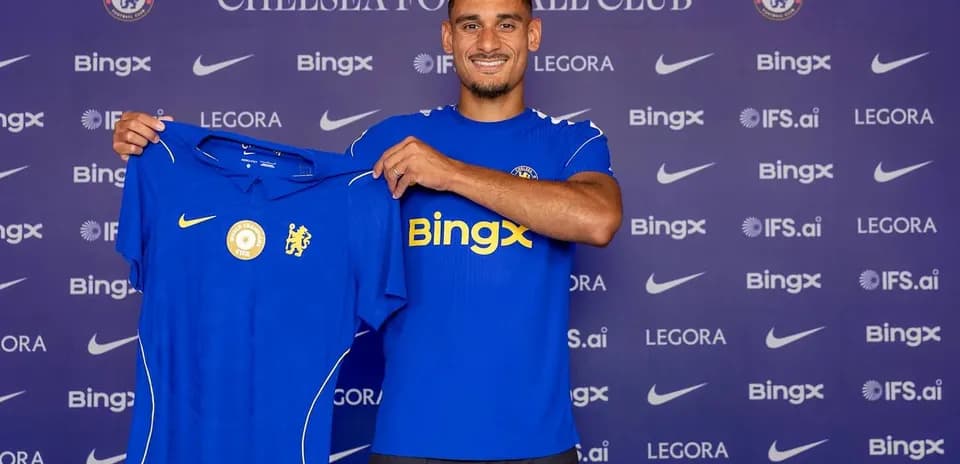 Player holding Chelsea jersey at announcement event