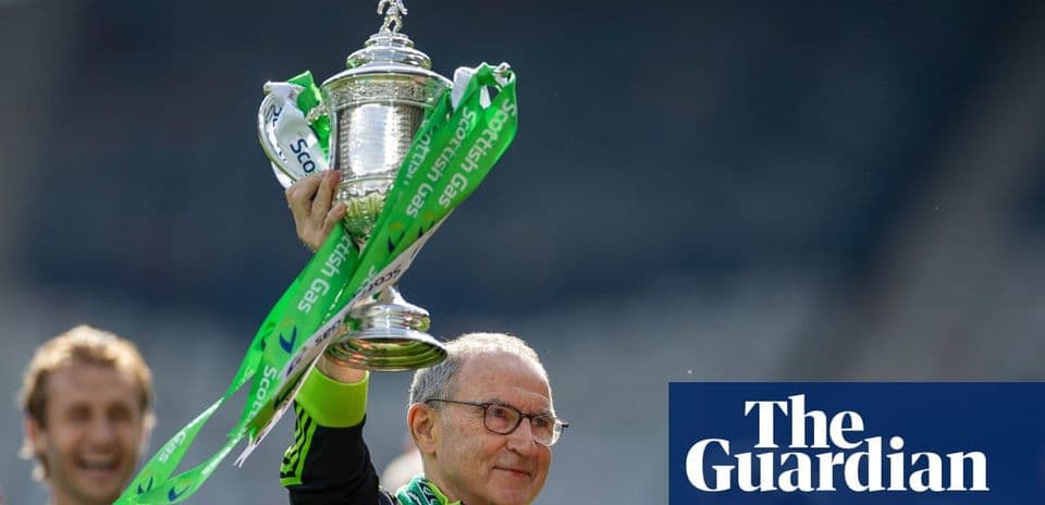 Person holding trophy with green ribbons aloft