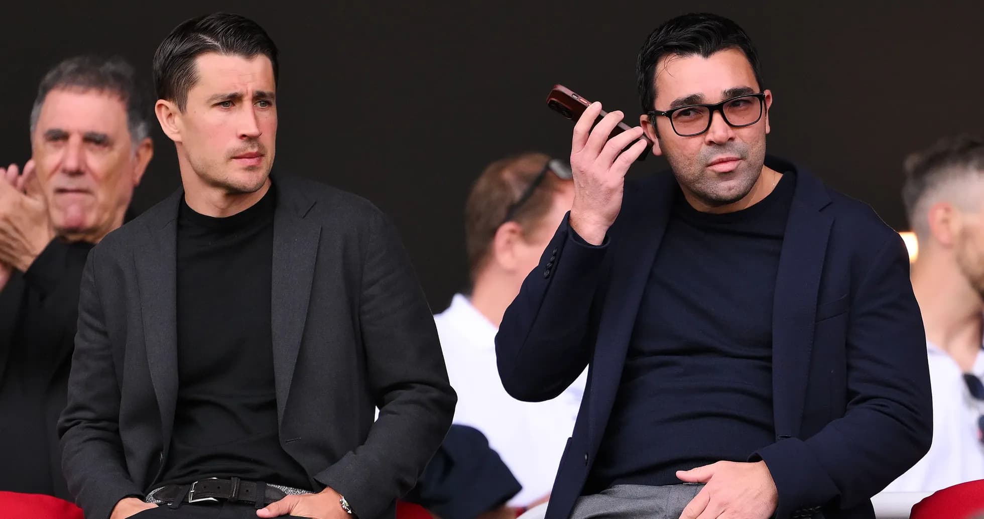 Two men seated in stands during an event