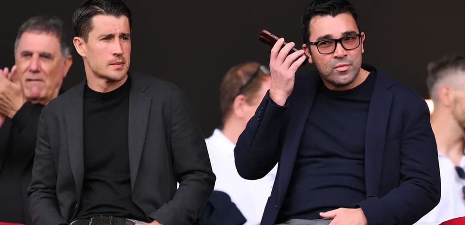 Two men seated in stands during an event