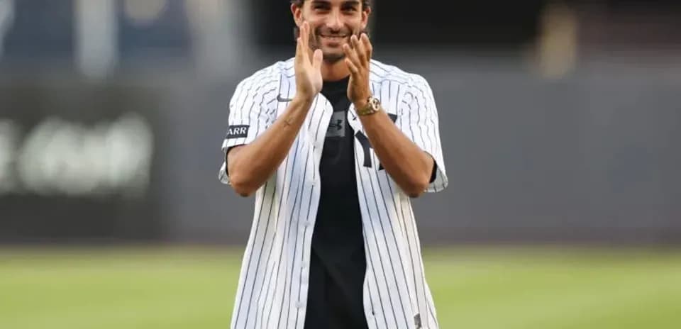 Man in Yankees jersey applauding at stadium