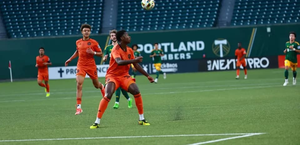 Players competing for the ball in MLS Next Pro match