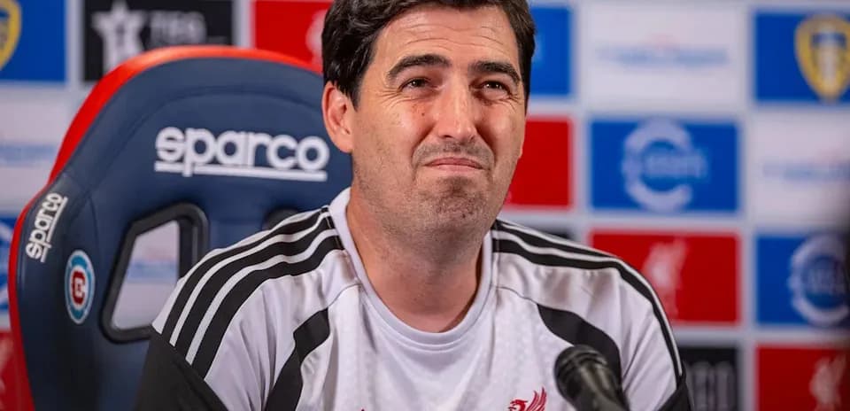 Manager speaking at press conference with Liverpool logo