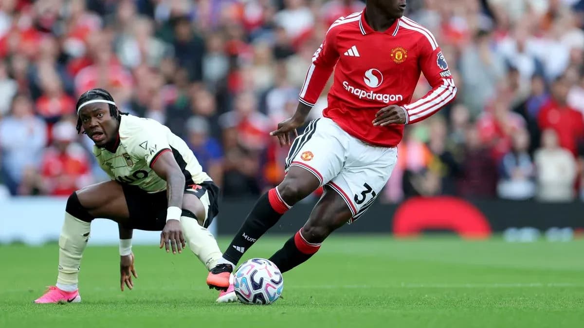 Manchester United player dribbling past opponent on field
