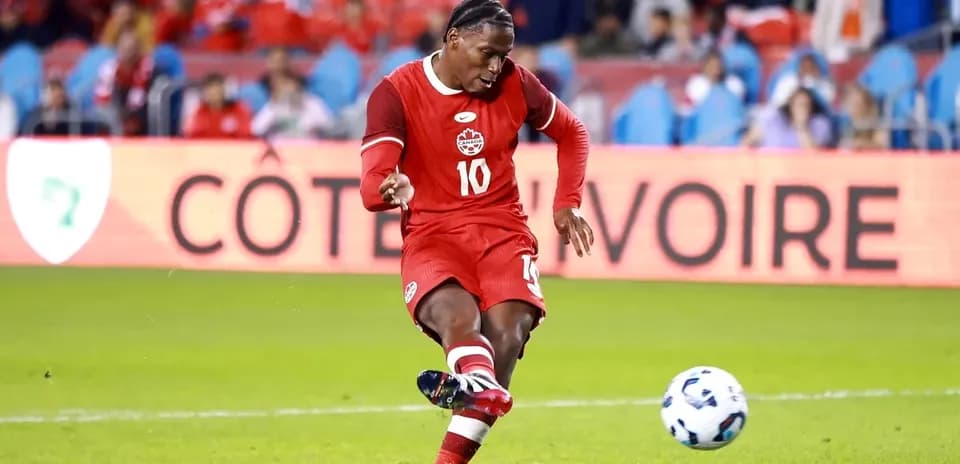 Player kicking ball during soccer match in stadium