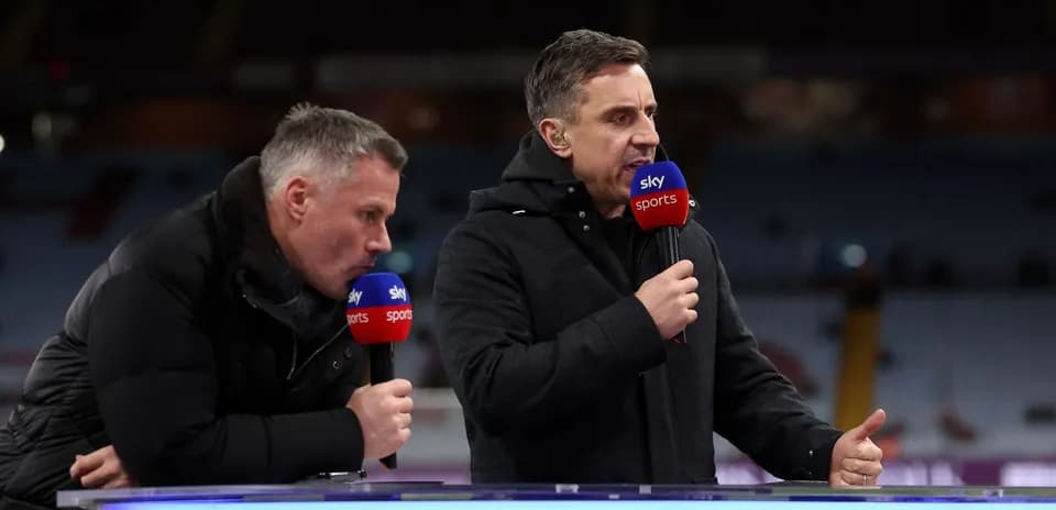 Two sports commentators speaking at broadcast desk