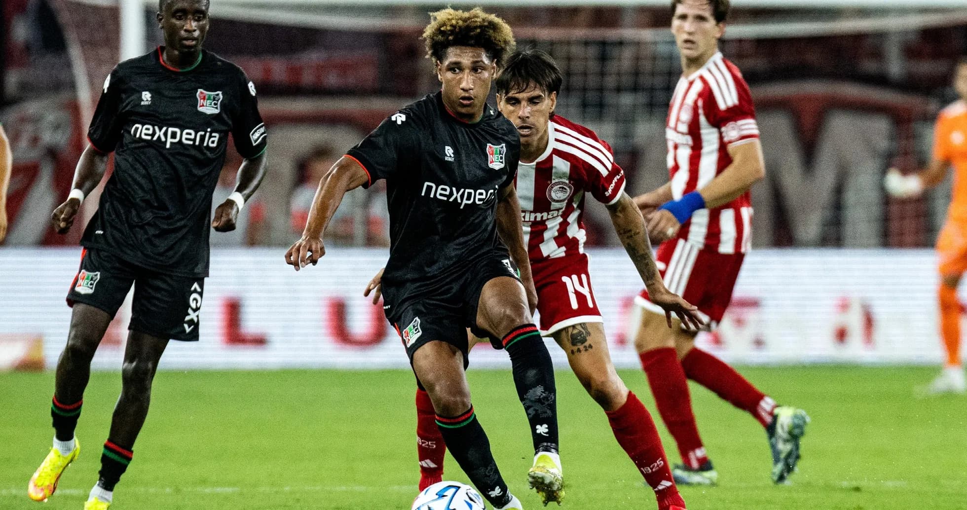 NEC player dribbling against Olympiakos defenders