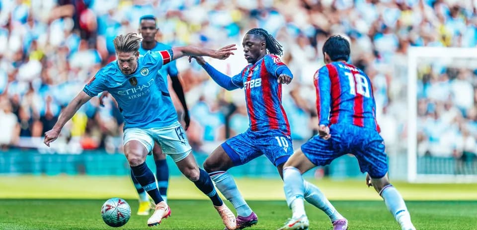 Manchester City player dribbling past Crystal Palace opponents