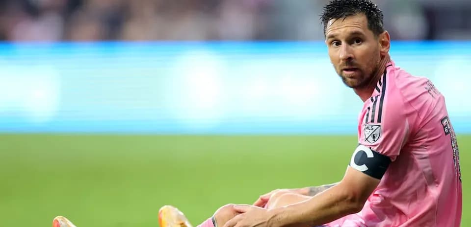 Player sitting on the field in pink jersey