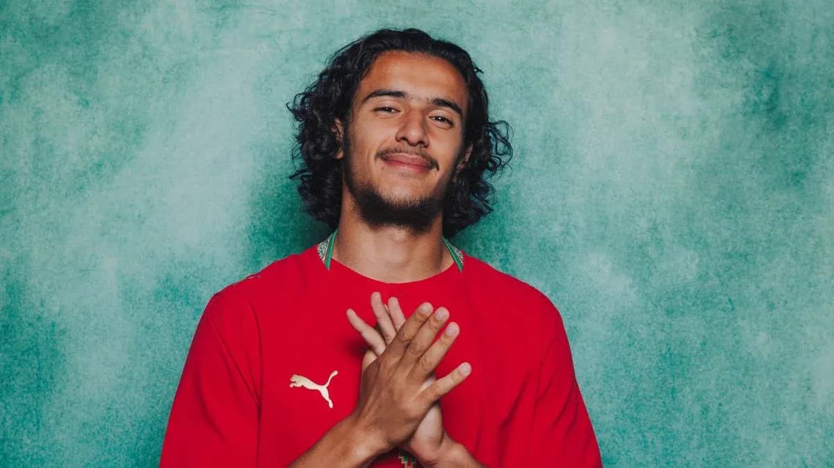 Player posing in red jersey with clasped hands