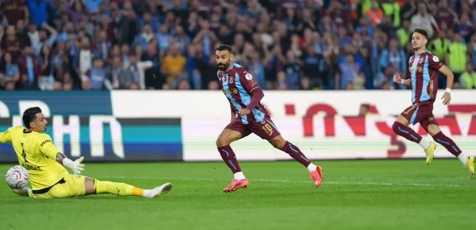 Player scoring while goalkeeper attempts to block shot