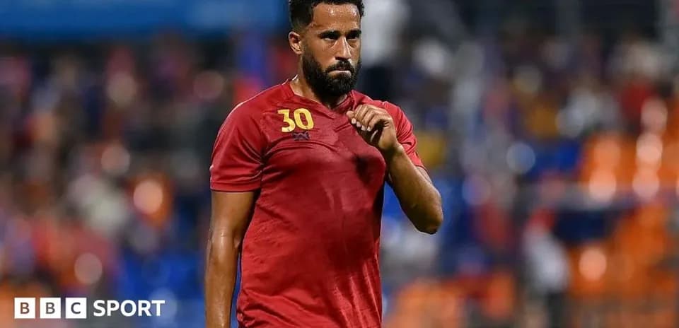 Player wearing red jersey walking on the field