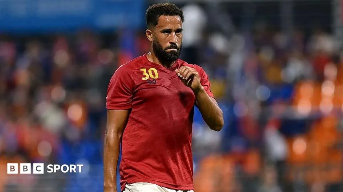 Player wearing red jersey walking on the field