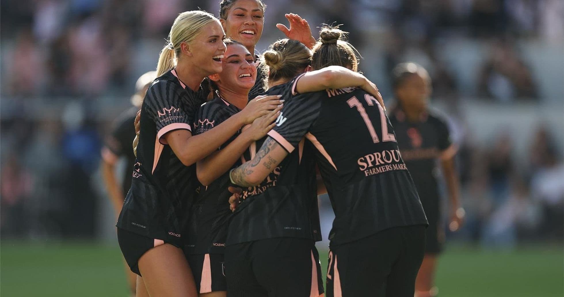 Players celebrating a goal during NWSL match