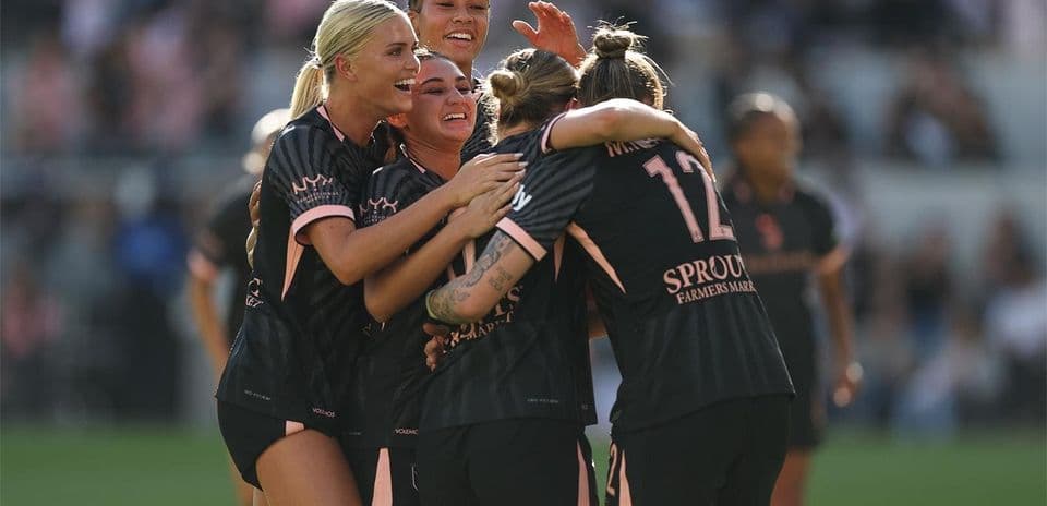 Players celebrating a goal during NWSL match