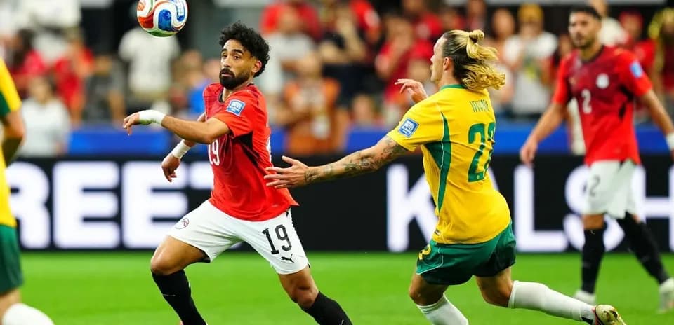 Egyptian player dribbling past Australian opponent in match