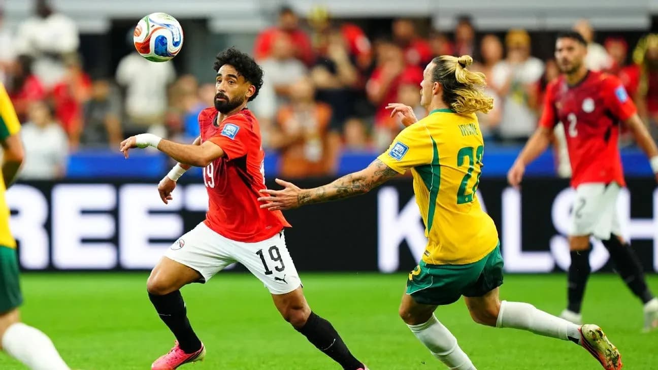 Egyptian player dribbling past Australian opponent in match