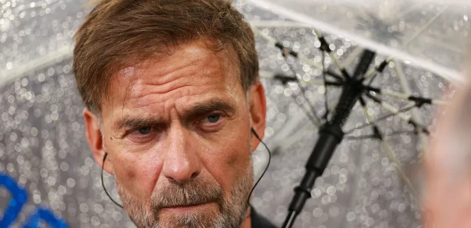 Coach under an umbrella during press conference