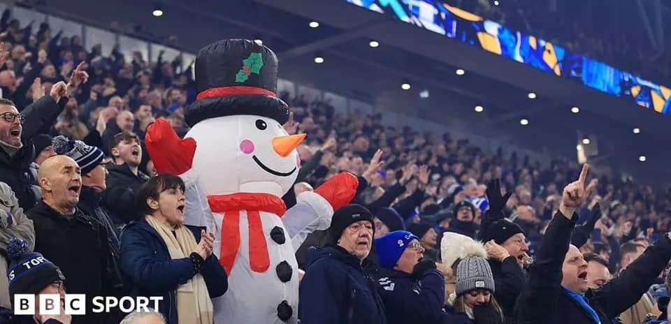 Fans cheering with a large snowman mascot
